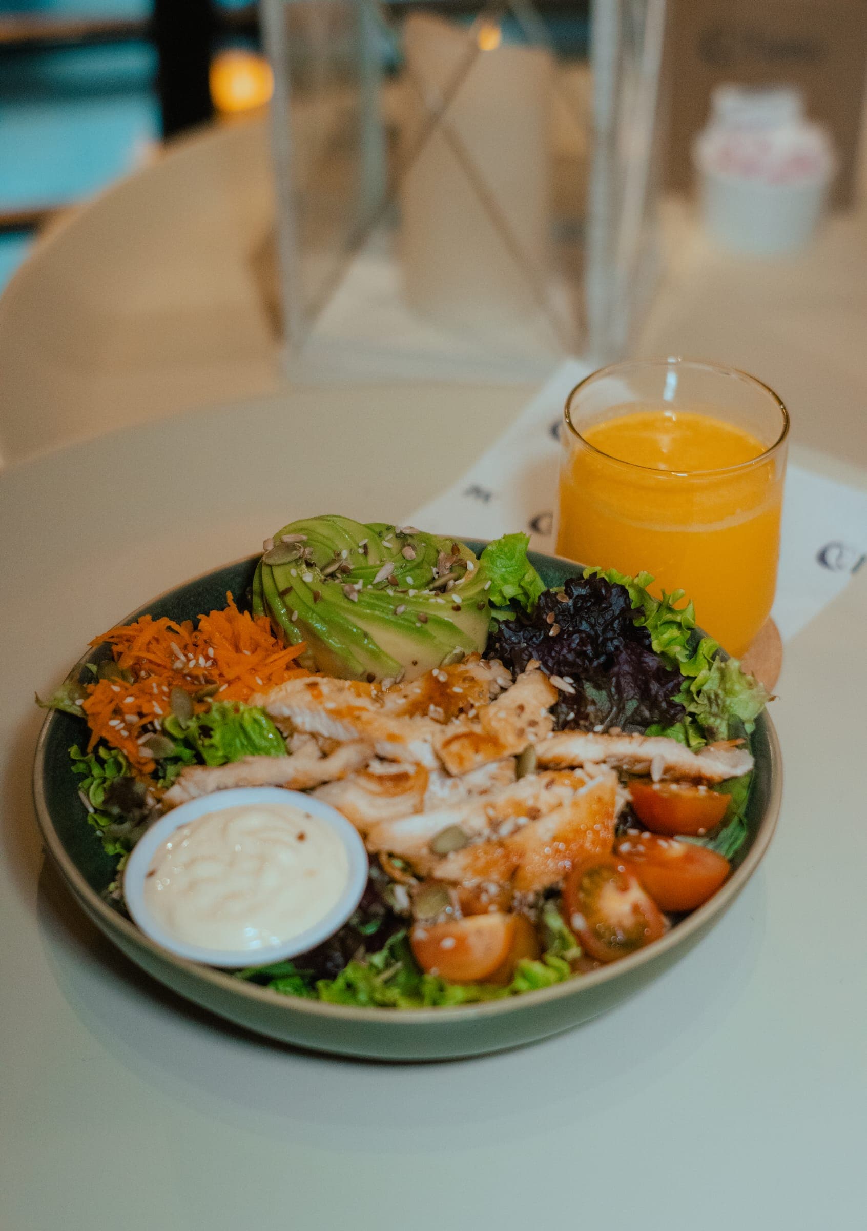 Ensalada y jugo con el interior de BAW Coffee al fondo